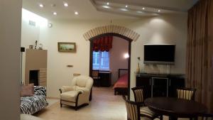 - un salon avec un canapé, une table et une télévision dans l'établissement Asmenos apartamentai, à Vilnius