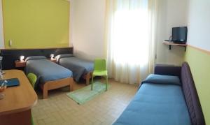 Pokój szpitalny z dwoma łóżkami i stołem w obiekcie Hotel Bermuda w mieście Marina di Ravenna