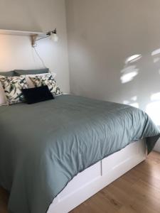 Bett mit grüner Decke in einem Zimmer in der Unterkunft Secret Camões in Porto