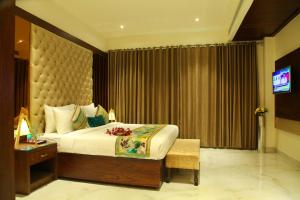 a hotel room with a bed and a television at Hotel WJ Grand in Jalandhar