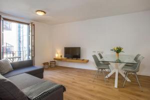 a living room with a table and a tv at Flateli Cort Reial in Girona