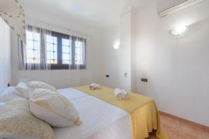 une chambre blanche avec un lit avec des serviettes dessus dans l'établissement Villa Tortugas, 5 min ibiza City, à Ibiza