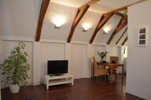 a living room with a tv and a table at Rembrandtplein Bed & Breakfast in Amsterdam