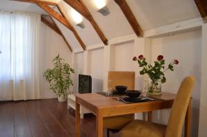 a dining room with a wooden table with flowers on it at Rembrandtplein Bed & Breakfast in Amsterdam