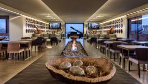 埃武拉维多利亚之石酒店的一间带壁炉和桌椅的餐厅