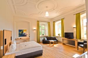 ein großes Wohnzimmer mit einem Bett und einem Sofa in der Unterkunft Hotel Kloster Holzen in Allmannshofen