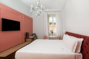 a bedroom with a white bed and a red wall at Boutique Centrale Palace Hotel in Rome