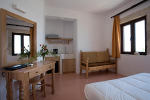 a bedroom with a bed and a desk and a kitchen at Elia in Kavoúsion