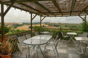 un patio con mesas, sillas y una pérgola en Logis - Le relais des deux vallées, en Salvagnac