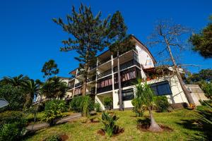 an apartment building with trees in front of it at Apartamento Vista Oceano in Caniço