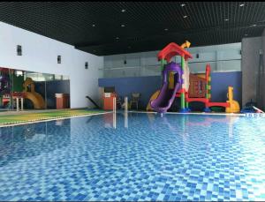 - une piscine avec toboggan dans un bâtiment dans l'établissement The Grand Condotel, à Vung Tau