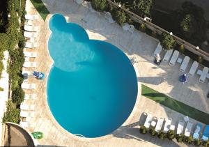 an overhead view of a blue pool with chairs and tables at Surmeli Istanbul Hotel in Istanbul