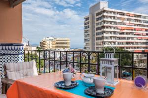 a table on a balcony with a view of a city at Apartamento Imperial in Torremolinos