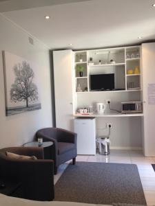 un soggiorno con un divano e una TV di The Palm in Pinelands a Città del Capo