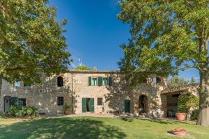 カーゾレ・デルザにあるPodere I Casini by VacaVillaの緑の扉と庭のある古い石造りの家
