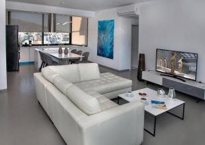 a white living room with a white couch and a table at Luxury Penthouse touching the Acropolis by GHH in Athens