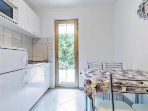 a kitchen with a table with chairs and a refrigerator at Apartments & Rooms Nikica in Baška