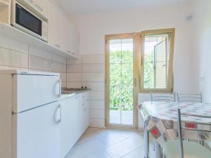 a kitchen with a white refrigerator and a table at Apartments & Rooms Nikica in Baška