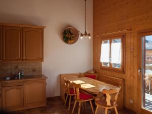 a kitchen with a wooden table and some chairs at Chalet Skilift in Rosswald