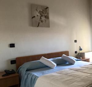 a bedroom with two beds and a painting on the wall at Hotel Ristorante Gallo D'Oro in Vignola
