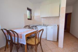 a kitchen with a table and chairs and a sink at Apartments Vera in Malinska +9 photos