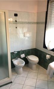 a bathroom with a toilet and a sink at Hotel Ristorante Gallo D'Oro in Vignola
