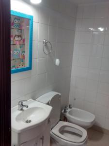 a white bathroom with a toilet and a sink at Departamento Plaza Moreno con balcón in La Plata