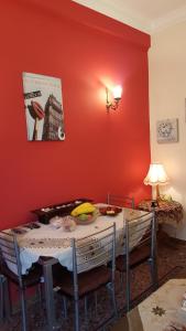 une salle à manger avec une table et un mur rouge dans l'établissement KOKONI APARTMENTS AMBELOKIPI, ATHENS, à Athènes