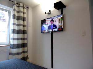 ワルシャワにあるSpichlerz II Old Town Apartmentの壁に薄型テレビが備わる客室です。