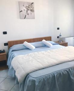 - une chambre dotée d'un grand lit avec des draps bleus et blancs dans l'établissement Hotel Ristorante Gallo D'Oro, à Vignola