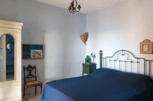 Un dormitorio con una cama azul y un espejo. en Villa Juno in Kea, en Koundouros 27 fotos más