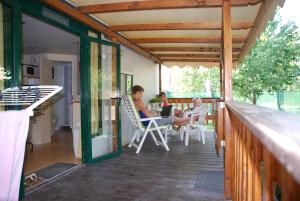 a group of people sitting on a deck with a laptop at Brevar - Toscane in Torre del Lago Puccini