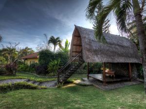 Casa pequeña con techo de paja y escalera en Puri Mangga Sea View Resort and Spa, en Lovina