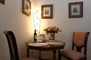 a wooden table with a vase of flowers on it at Houspitality Caesar Bed & Breakfast in Rome