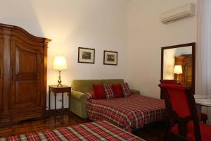 a living room with a green couch and a table at Houspitality Caesar Bed & Breakfast in Rome