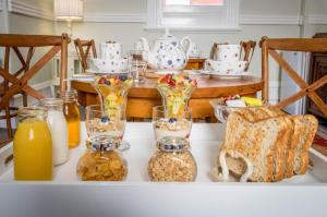 a table topped with jars of breakfast foods and orange juice at Fremantle Bed & Breakfast in Fremantle