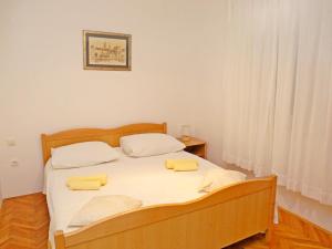 a bedroom with a bed with two yellow towels on it at Apartments Slavko in Trogir