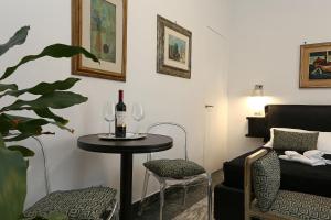 a room with a table with a bottle of wine and a chair at Houspitality Caesar Bed & Breakfast in Rome