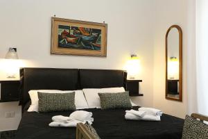 a bedroom with a black bed with towels on it at Houspitality Caesar Bed & Breakfast in Rome