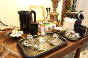 a tray of glass cups and dishes on a table at Houspitality Caesar Bed & Breakfast in Rome