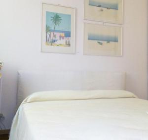 ニースにあるAppartement La Cerisaie - Rue Massenaのベッドルーム1室(壁に2枚の写真が飾られたベッド1台付)
