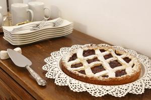 a cake sitting on a table with a plate and a pie at Houspitality Caesar Bed & Breakfast in Rome