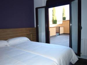 a bedroom with a white bed and a large window at Hotel Las Casas de Pandreula in Berlanga de Duero
