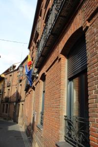 a brick building with a kite hanging on the side of it at Albergue Muralla Leonesa in León