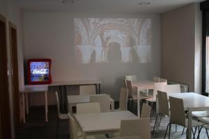 a dining room with tables and chairs and a tv at Albergue Muralla Leonesa in León