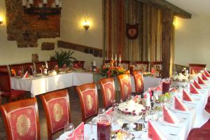 a long table with white tables and chairs in a room at Pūteļkrogs in Tērvete