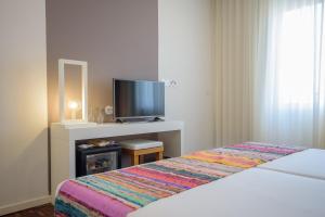 Tempat tidur dalam kamar di Oasis Porto Grande