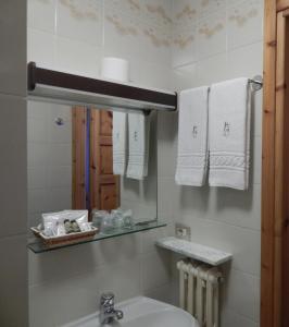 W łazience znajduje się umywalka, lustro i ręczniki. w obiekcie Hotel Valdotain w mieście Villeneuve