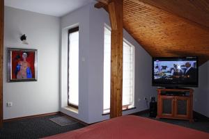 a bedroom with a flat screen tv and windows at Boutique Hotel St. Stefan in Nesebar