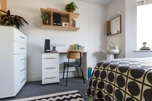 a bedroom with a desk and a bed and a chair at Roseland House in Falmouth